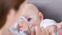 Baby looks at mom while breastfeeding
