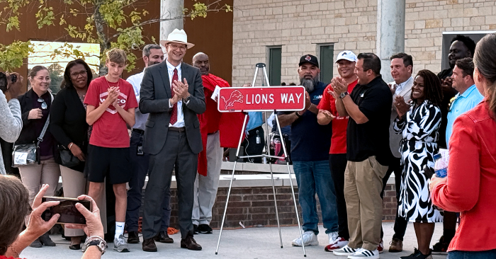 group of people with a new street sign