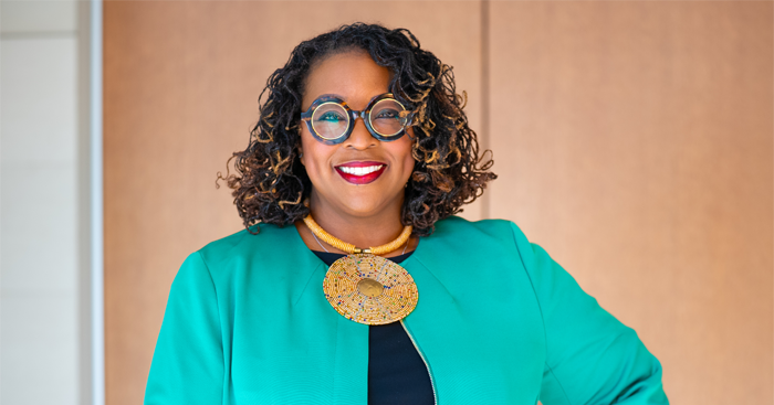 Andrea J. Barefield wearing a green jacket and a statement necklace
