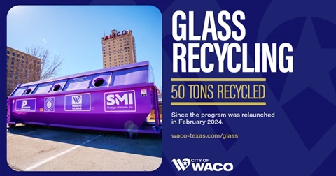 Large purple glass recycling dumpster in front of a blue sky and the ALICO building