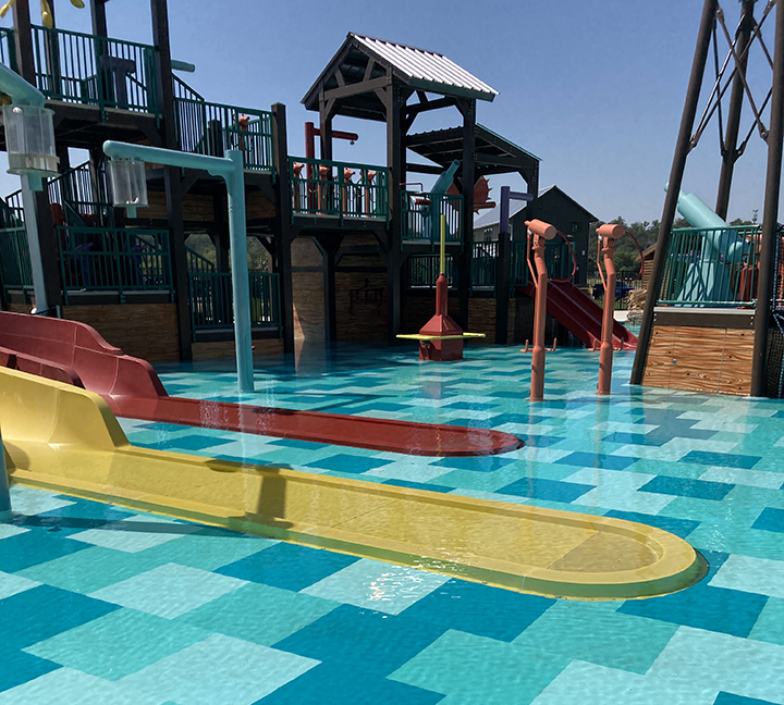 Bright and sunny picture of a pool and waterpark area that was inspected.