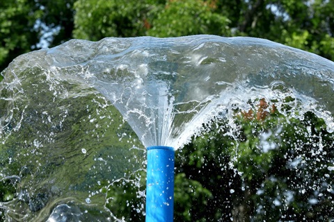 Photo of a splash pad feature shooting water in every direction.